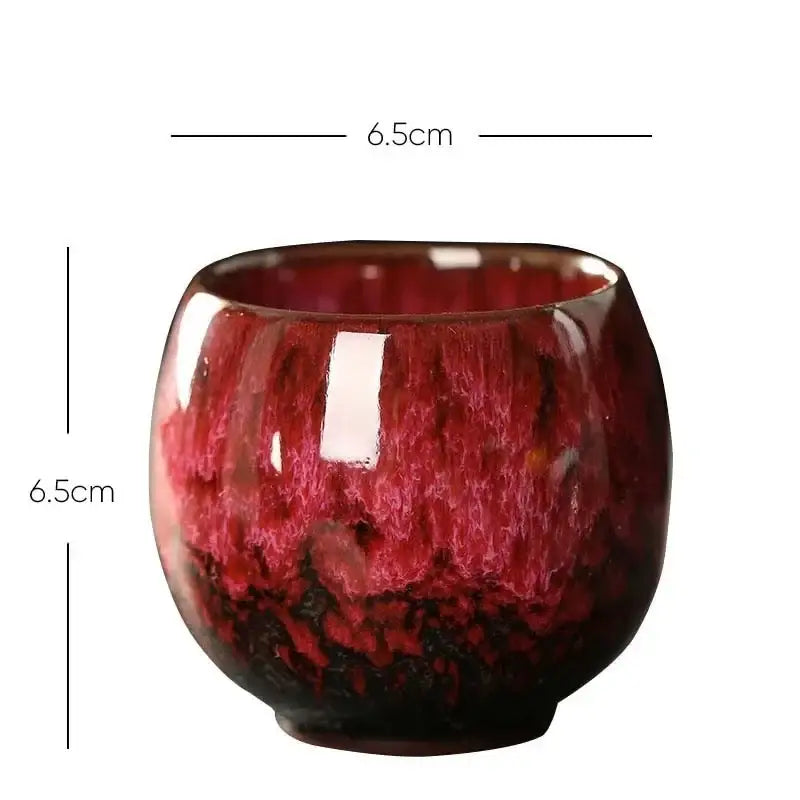 A handcrafted egg style ceramic tea cup with a glossy deep red to maroon gradient glaze for elegant dining