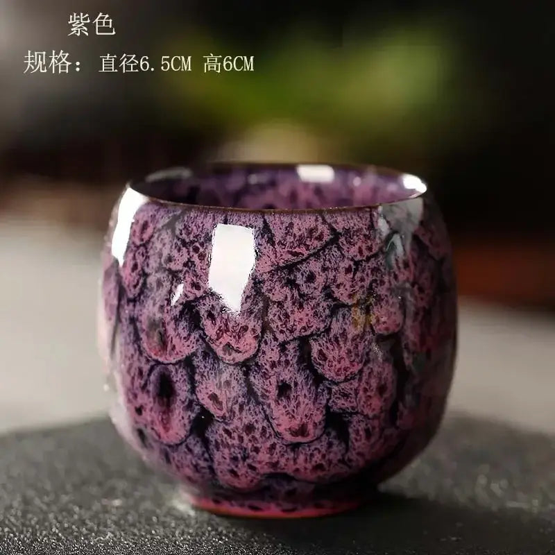 A glossy purple egg style ceramic tea cup with a textured scale-like glaze in a handcrafted tea cup set