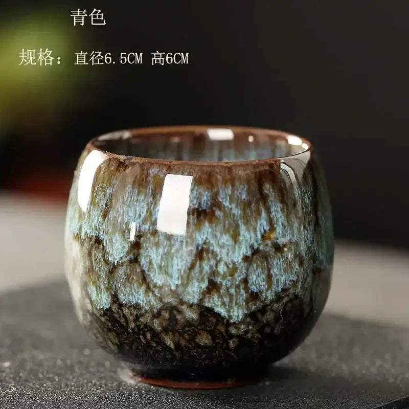 Handcrafted egg style ceramic tea cup with a glossy teal and brown mottled glaze for dining room use