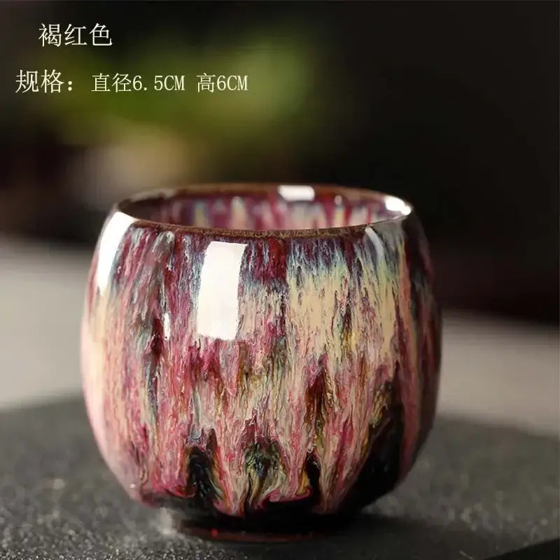 Handcrafted colorful egg style ceramic tea cup with glossy swirling glaze of deep reds purples and cream tones