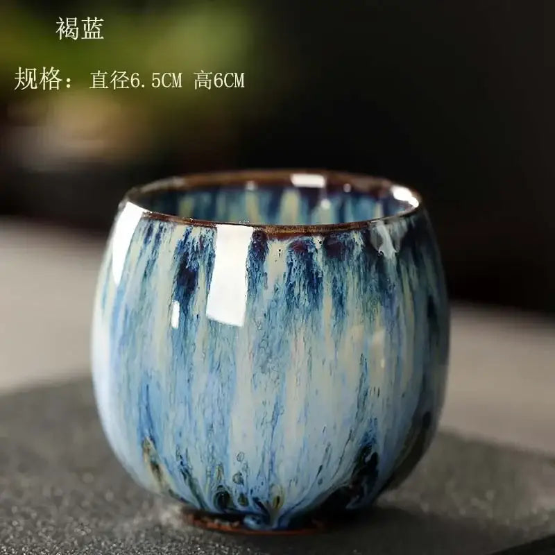 Handcrafted colorful egg style ceramic tea cup with glossy blue and white glaze dripping down rounded sides for dining