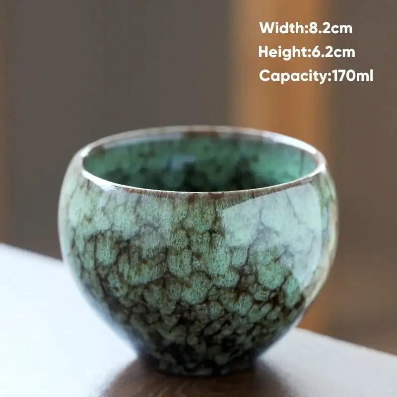 Handcrafted ceramic coffee cup with crackle glaze in teal and brown featuring an organic textured surface