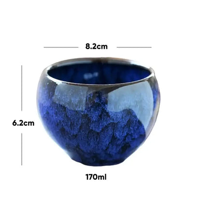 Handcrafted ceramic coffee cup with glossy deep blue crackle glaze and slightly flared rim for dining room use