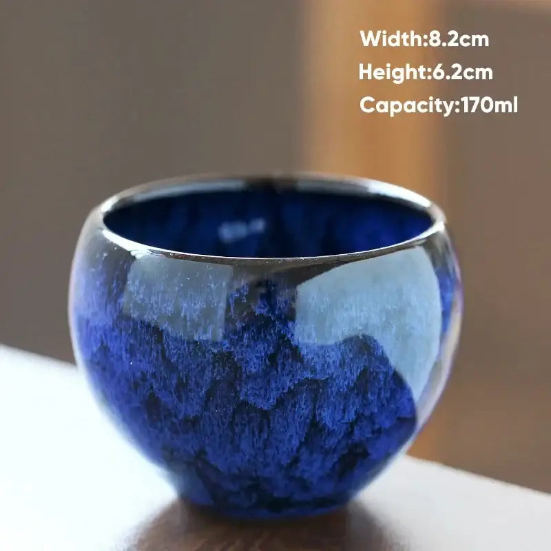 Handcrafted ceramic coffee cup with a glossy deep blue crackle glaze and smooth silver rim for dining room use
