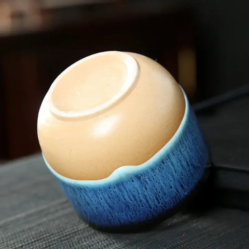 Handcrafted ceramic kung fu tea cup with smooth beige interior and vibrant blue textured glaze for decorbites drinkware