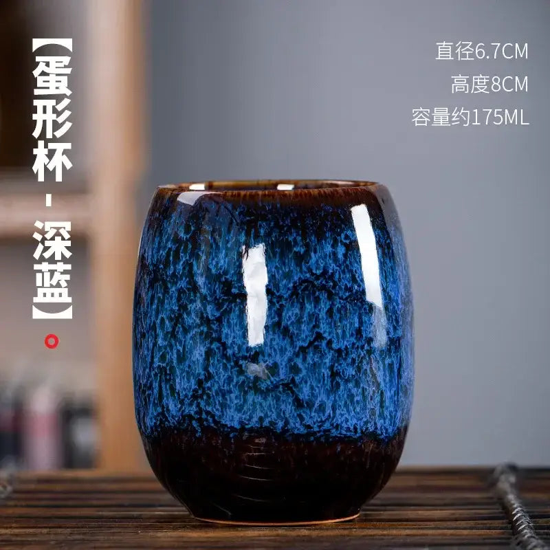 Handcrafted deep blue ceramic tea cup with glossy crackled glaze and dark brown base in a tea cup set for dining room