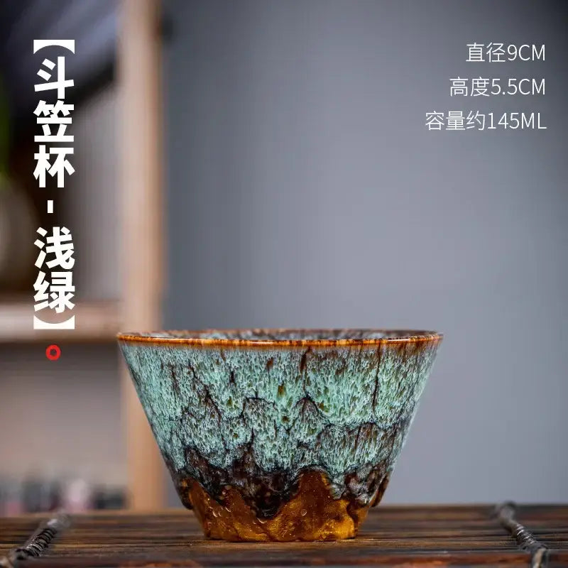 Handcrafted multicolored ceramic tea cup with textured teal and brown glaze from a tea cup set for dining room use