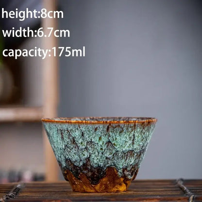 Handcrafted multicolored ceramic tea cup with textured teal and brown glaze in a tea cup set for dining room use
