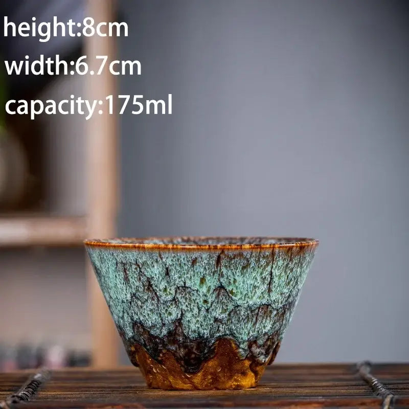 Handcrafted multicolored ceramic tea cup with textured teal and brown glaze in a tea cup set for dining room use