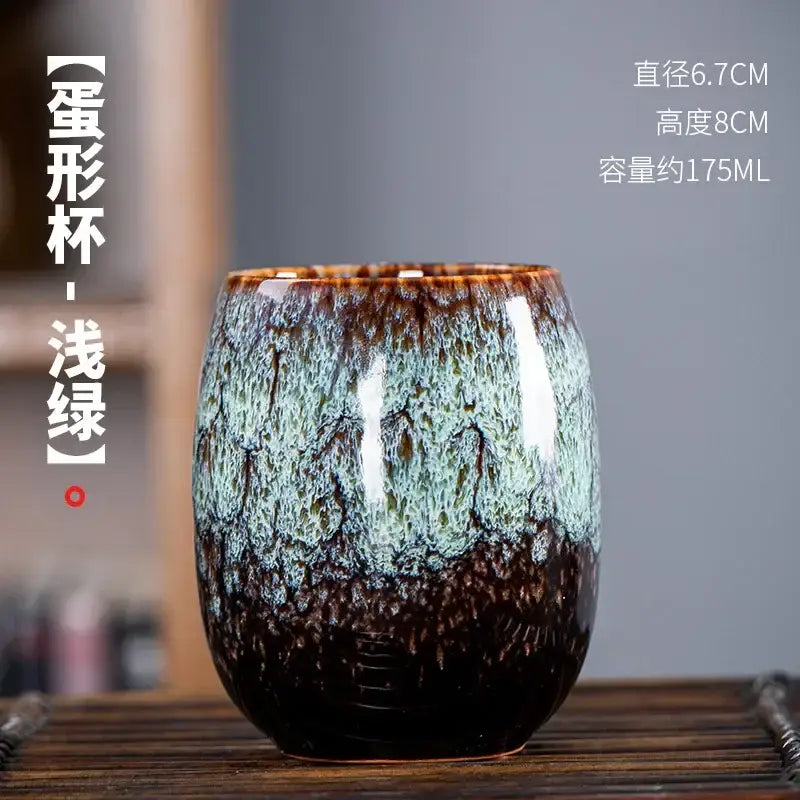 Handcrafted ceramic tea cup with glossy crackled glaze in brown to teal green part of a multicolored cup set