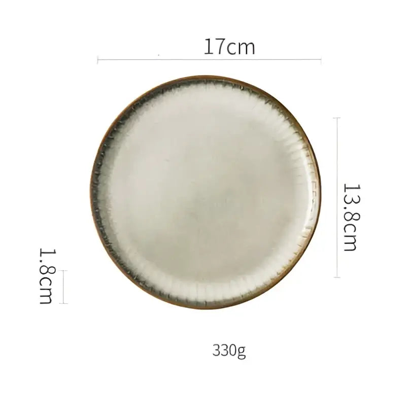 A handcrafted 17cm decorbites ceramic dessert plate with off-white glaze and textured dark brown rim for dining room use