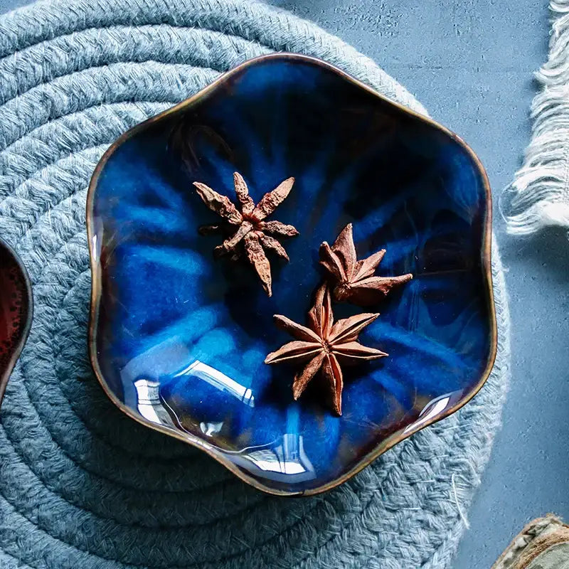 Handcrafted gloss cobalt blue decorbites ceramic japanese style scalloped dipping bowl with brown rim holding star anise