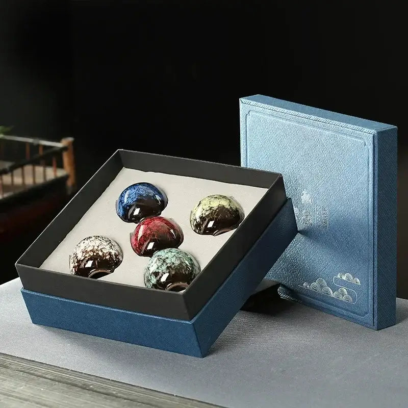 Five glossy multicolored ceramic cups set with iridescent glazes in a navy blue gift box by decorbites ceramic cups