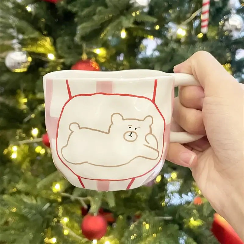Handcrafted white ceramic bear mug with red and white stripes featuring a sleeping bear in a hammock design