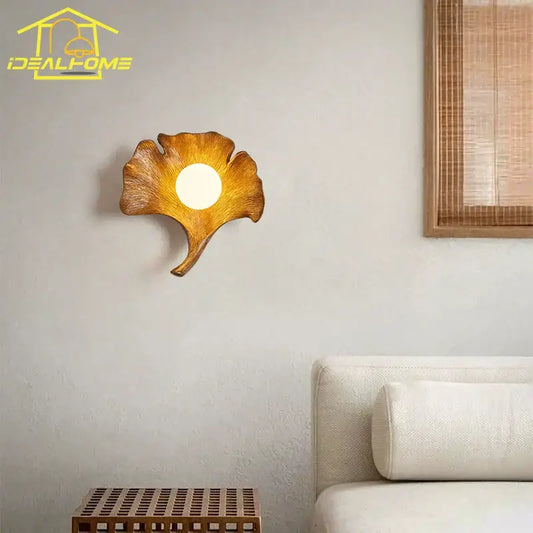 Warm-toned handcrafted wooden wall lamp shaped like a ginkgo biloba leaf with resin detail by decorbites for bedroom decor