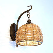 Handmade asian rattan dome wall sconce with brown rattan weave and dark bronze metal arm fixture type wall lamp