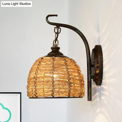 Handmade asian rattan dome wall sconce with a curved dark metal arm and golden-brown woven shade fixture type wall lamp