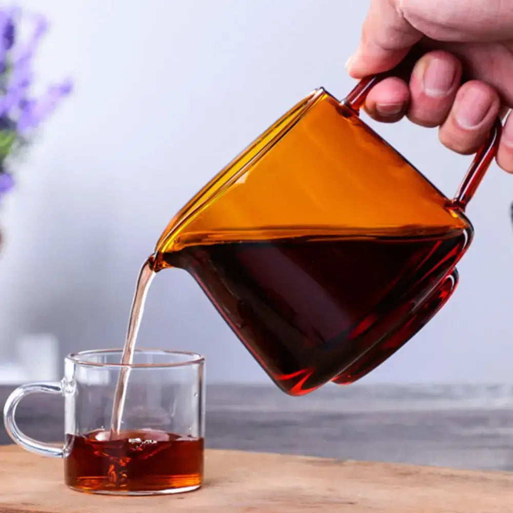 Amber-colored glass coffee sharing pot with sleek modern design and dual handles for kitchen brewing server use