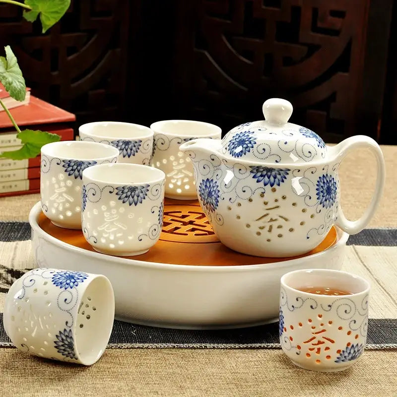 Handmade decorbites ceramic kung fu teapot with blue floral patterns and perforated design on orange tray