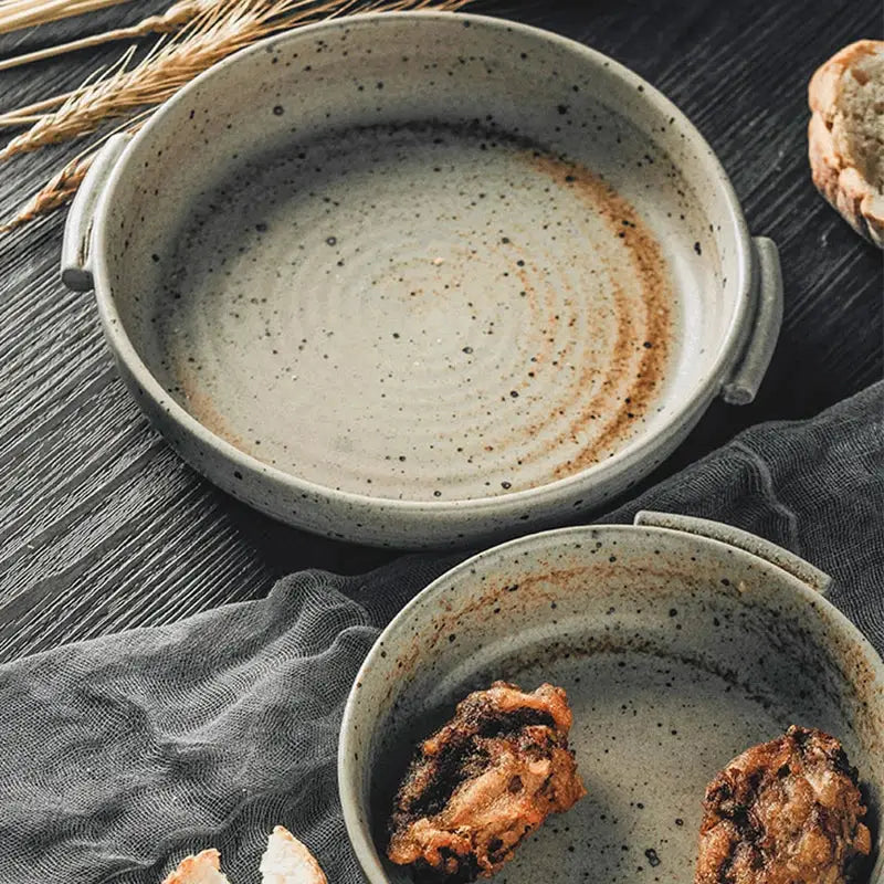 A handmade ceramic sushi plate set featuring a rustic speckled gray ceramic sushi plate with two handles