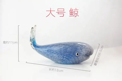 A translucent blue glass whale figurine with textured scales and a black eye for living room glass decor
