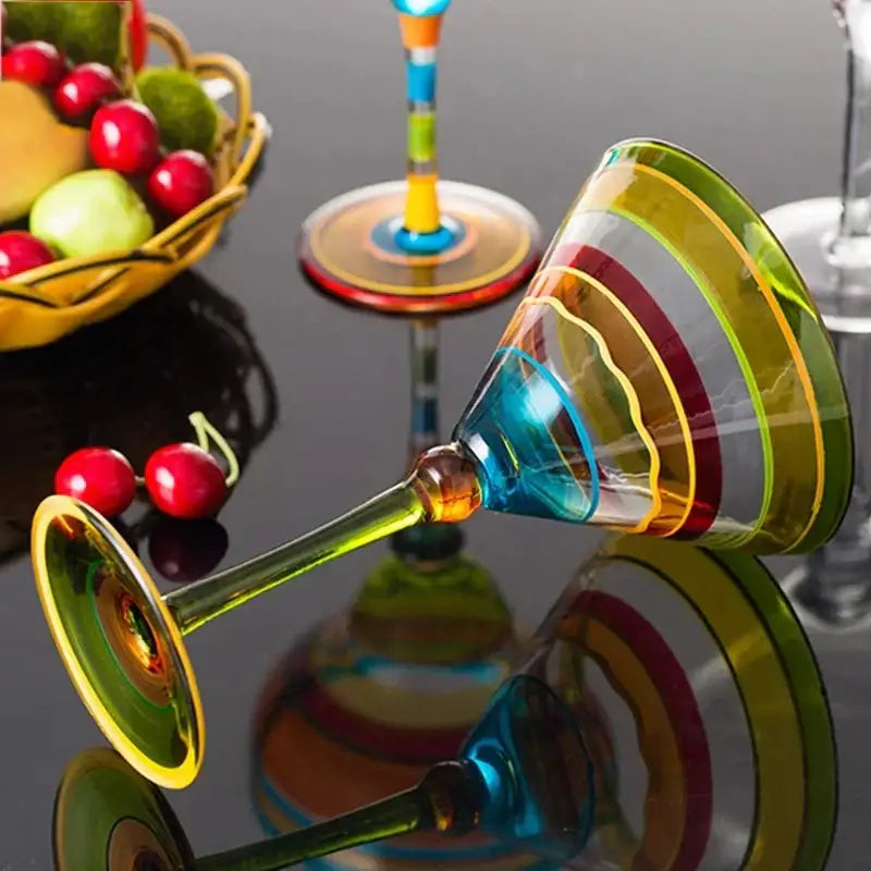 A decorbites handmade colorful margarita glass with hand-blown concentric rainbow stripes and a slender stem