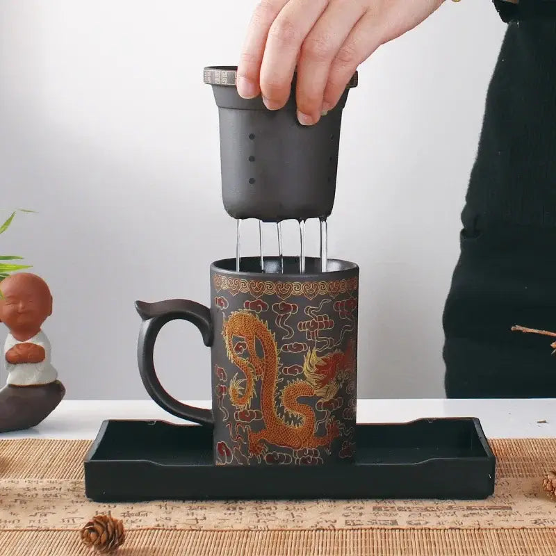 Black ceramic tea mug with golden dragon and red clouds, integrated strainer, part of decorbites dragon purple clay set