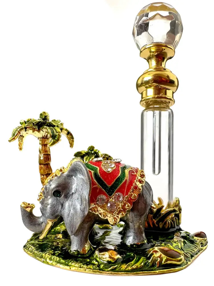 Handmade silver elephant figurine with red and green enamel and crystal next to a crystal perfume bottle bedroom decor