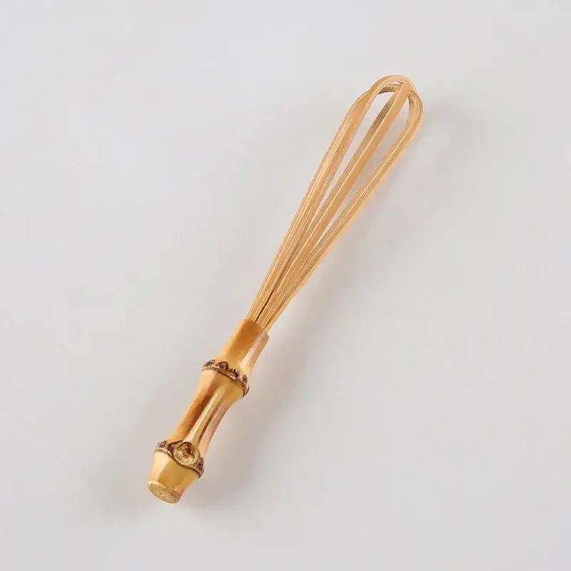 Handmade golden bamboo egg beater flour mixer with decorative segmented handle and fine wire loops for blending