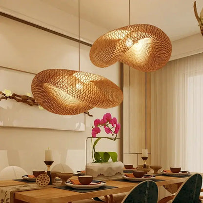 Two golden brown handmade bamboo wave pendant lights with organic design hang above the dining table
