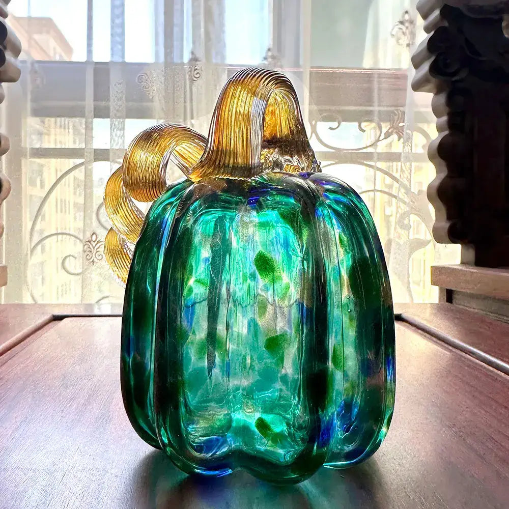 Handmade iridescent teal and green glass pumpkin figurines with golden ribbed stems for living room decor