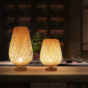 Two warm-toned handmade lattice woven bamboo table lamps with natural textured design and wooden bases for bedroom use