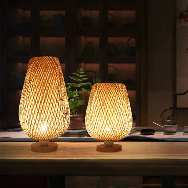 Two warm-toned handmade lattice woven bamboo table lamps with natural textured design and wooden bases for bedroom use