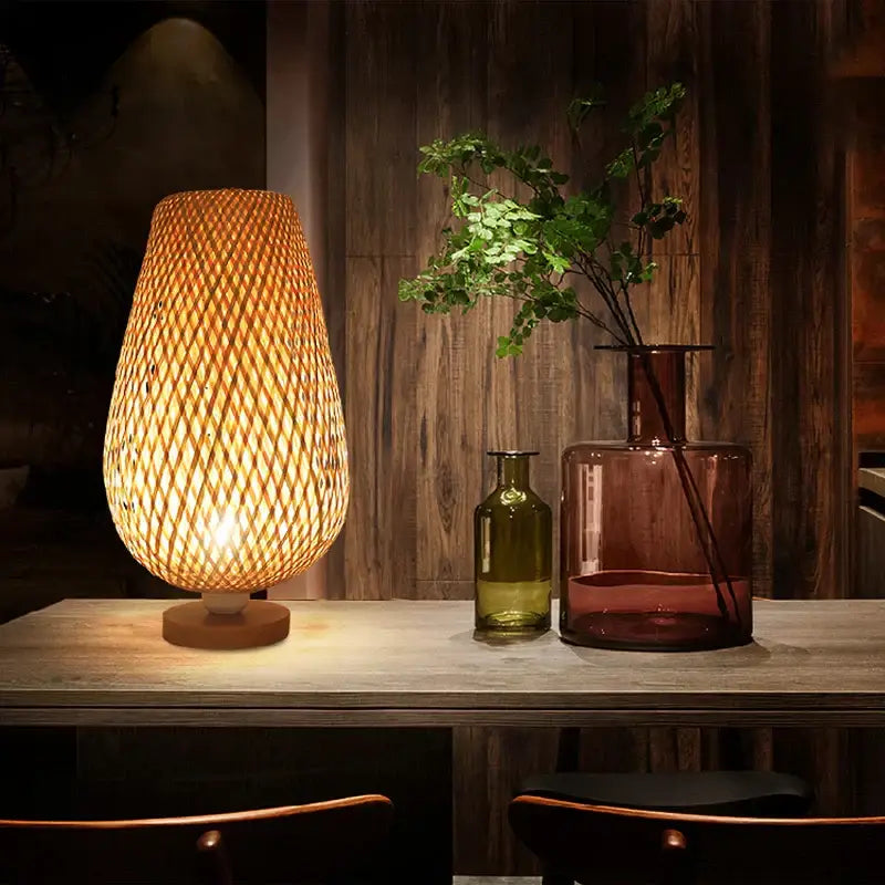 Warmly glowing handmade bamboo table lamp with a woven lattice shade and wooden base for bedroom use