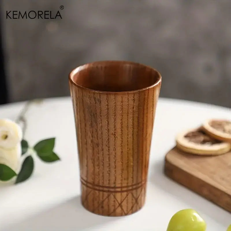 A kemorela handmade natural wooden tea tumbler with warm brown finish and engraved diamond lattice design near base