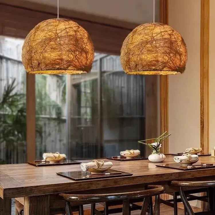 Two warm-toned handmade rattan bamboo pendant lamps with woven design hang above dining table for living room lighting
