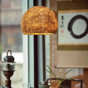 Warm-toned spherical pendant lamp crafted from handmade rattan bamboo for living room decor by decorbites