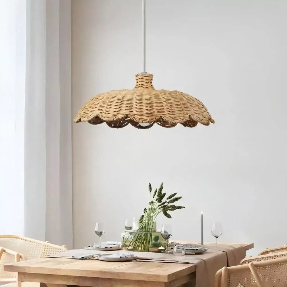 Beige handmade rattan pendant lamp with scalloped wicker design hanging from white cord for dining room use