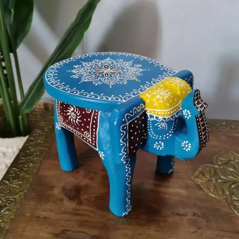 A vibrant blue hand-painted wooden elephant stool with white mandala patterns and yellow decorative saddle for decorbites elephant stool decor