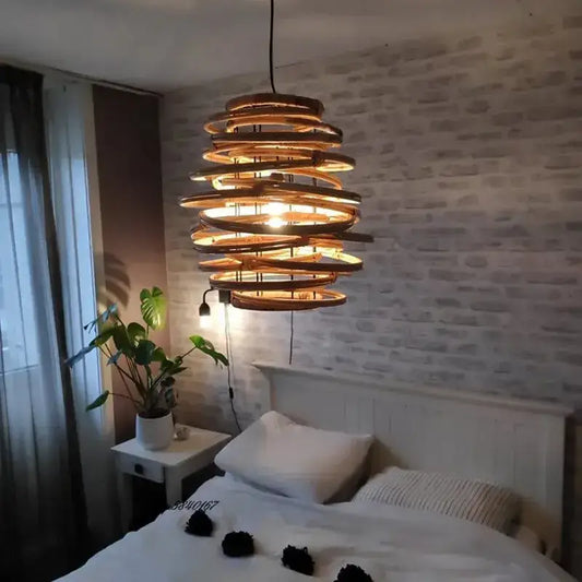 A warm-toned handmade tiered bamboo birdnest pendant light with spiral design hanging above the bed decorbites bamboo birdnest