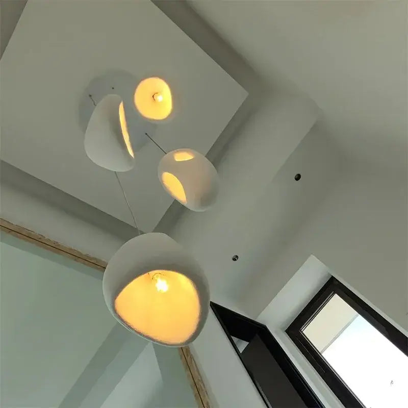 Modern white ceramic pendant lights with warm glowing interiors handmade wabi sabi stone pendant lights decorbites handmade wabi