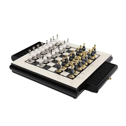 Elegant handmade wooden chess set with black and white marble and gold accents on a glossy foldable board