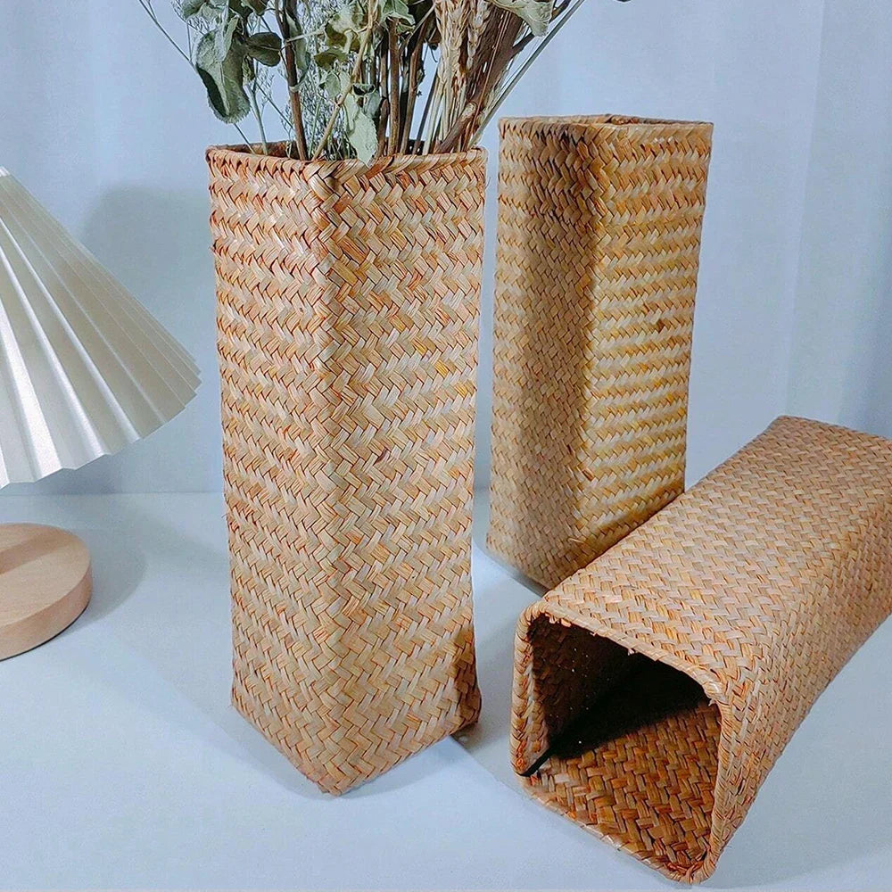 Handmade woven rectangular flower vase in natural beige straw with intricate herringbone patterns for home decoration
