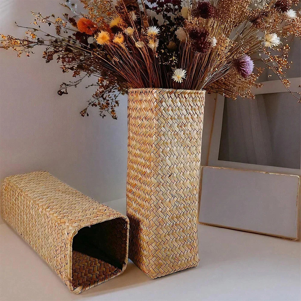 Tall rectangular handmade woven straw vase filled with warm earthy toned dried flowers for home decoration