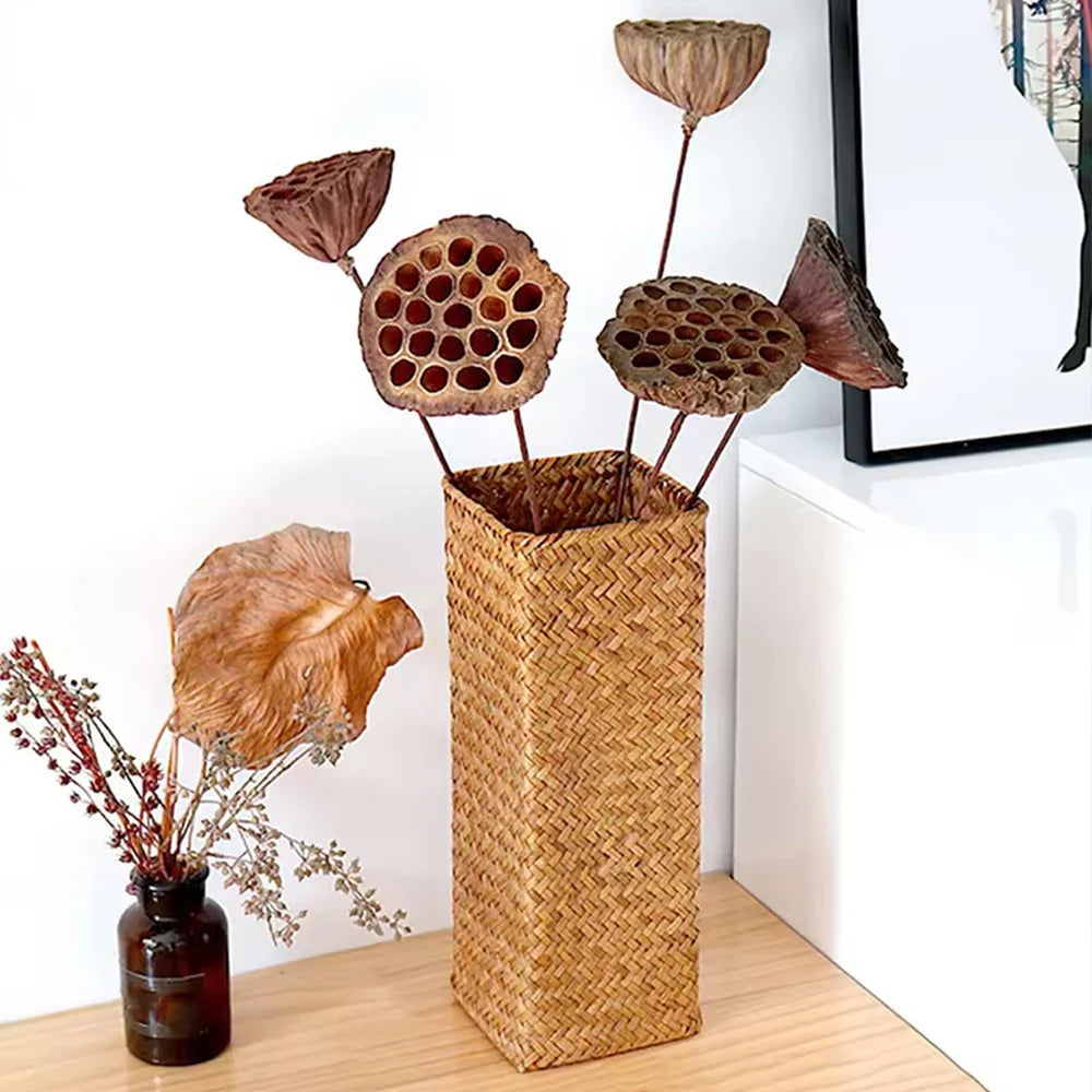Handmade tall rectangular woven straw vase holding dried lotus seed pods for creative home flower decoration