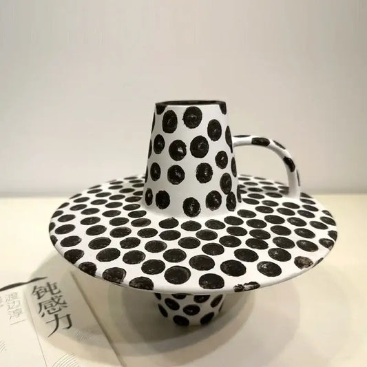A handpainted black white dots ceramic mug and saucer set featuring white dots in a decorbites black white design