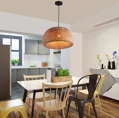 Handwoven beige tone bamboo pendant light with warm glowing amber interior made from natural materials for dining room