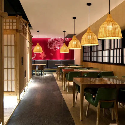 Handwoven black woven pendant light made of rattan with a warm golden glow suitable for dining room use