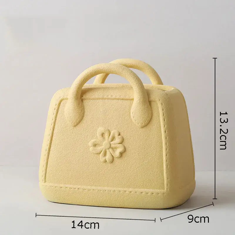 Pale yellow decorbites handwoven ceramic vase shaped like a handbag with embossed floral design for living room decor
