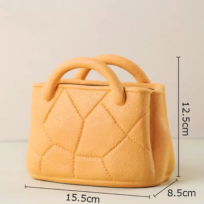 A miniature peach-colored felt handbag with quilted diamond pattern and rounded handles for decorbites handwoven ceramic vase decor